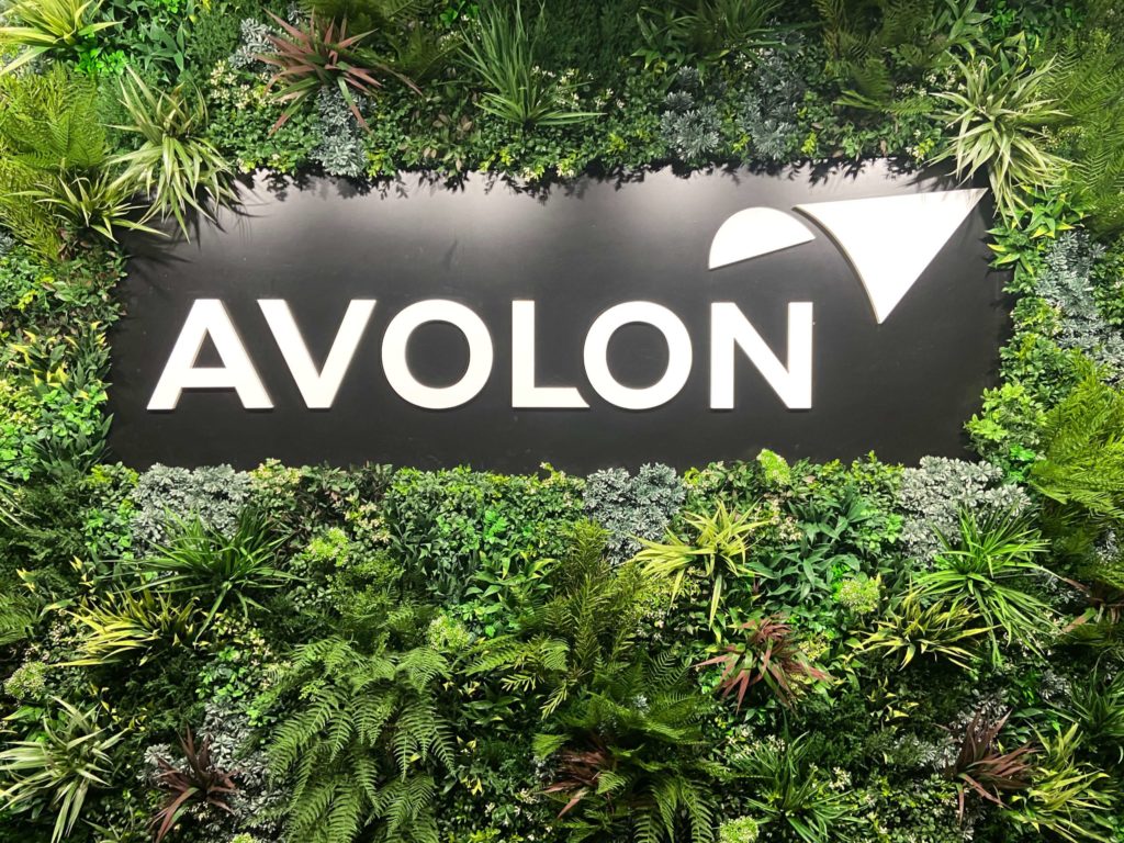 Avolon Logo lit with light in a Vistafolia Green Wall